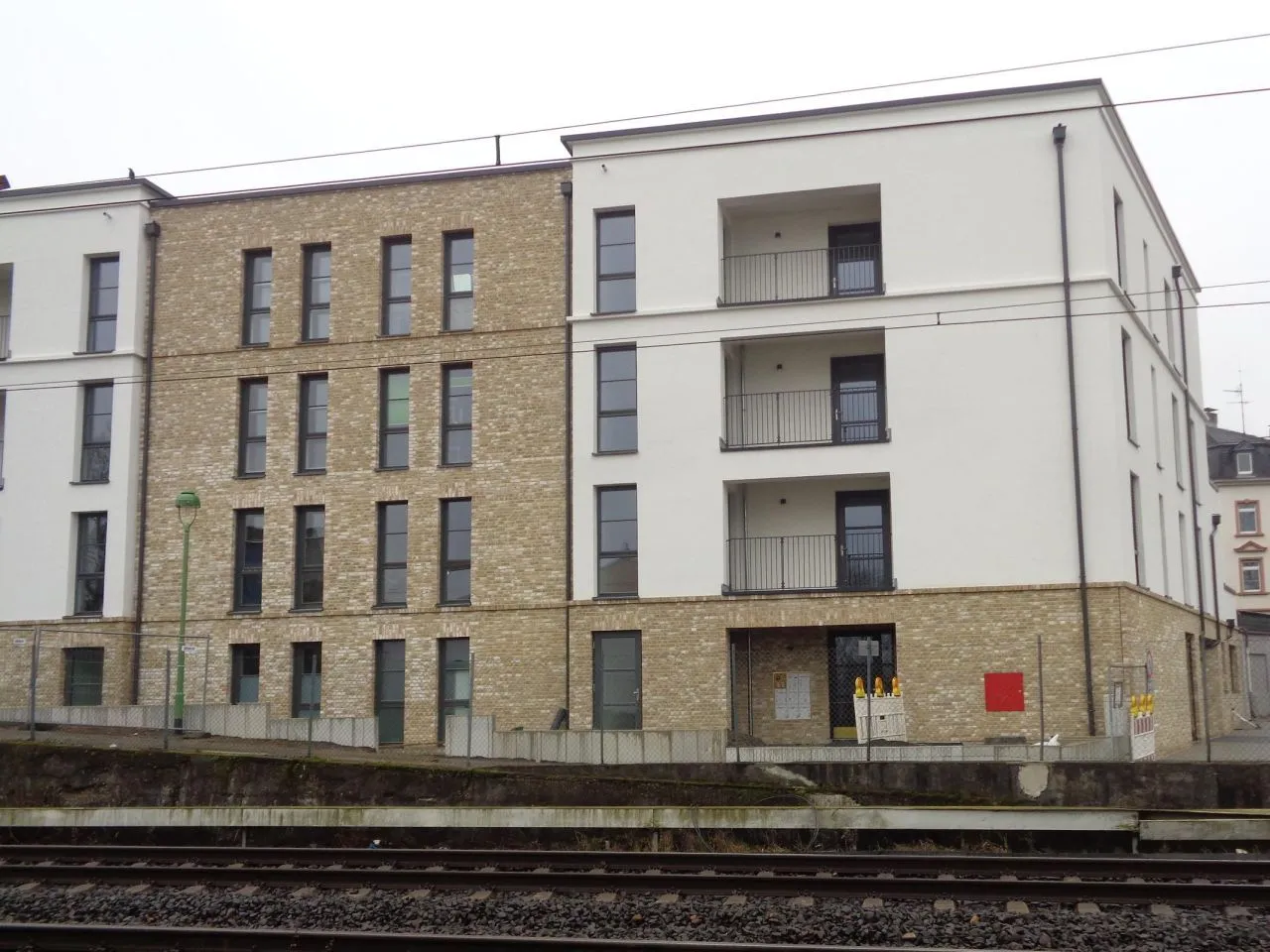 Backstein Außenfassade mit der Sorte Irish Moor. Die Hausfassade wirkt freundlich und hell. Mit den schmalen langen Fenstern in dunkel grau und der teilweisen Verputzung in weiß wirkt das Gesamtbild modern und stilvoll.