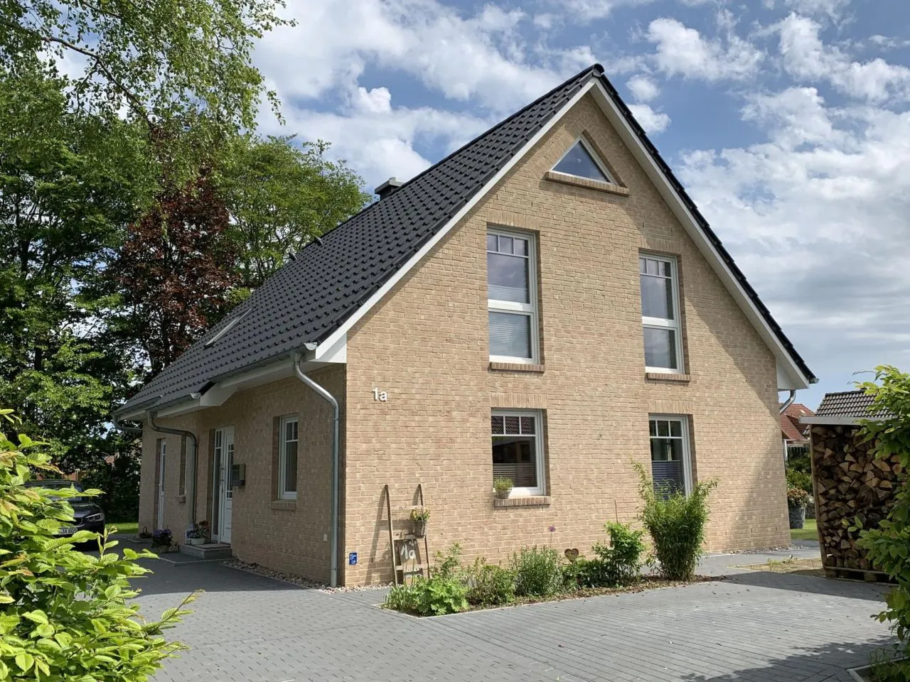 Hausfassade mit den Klinkerriemchen Sandgelb. Eine schöne gelbe Außenfassade. Es wurden mit roten Backsteinriemchen Akzente gesetzt. Ein insgesamt helle, freundliches und klassisches und zeitgleich modernes  Haus.